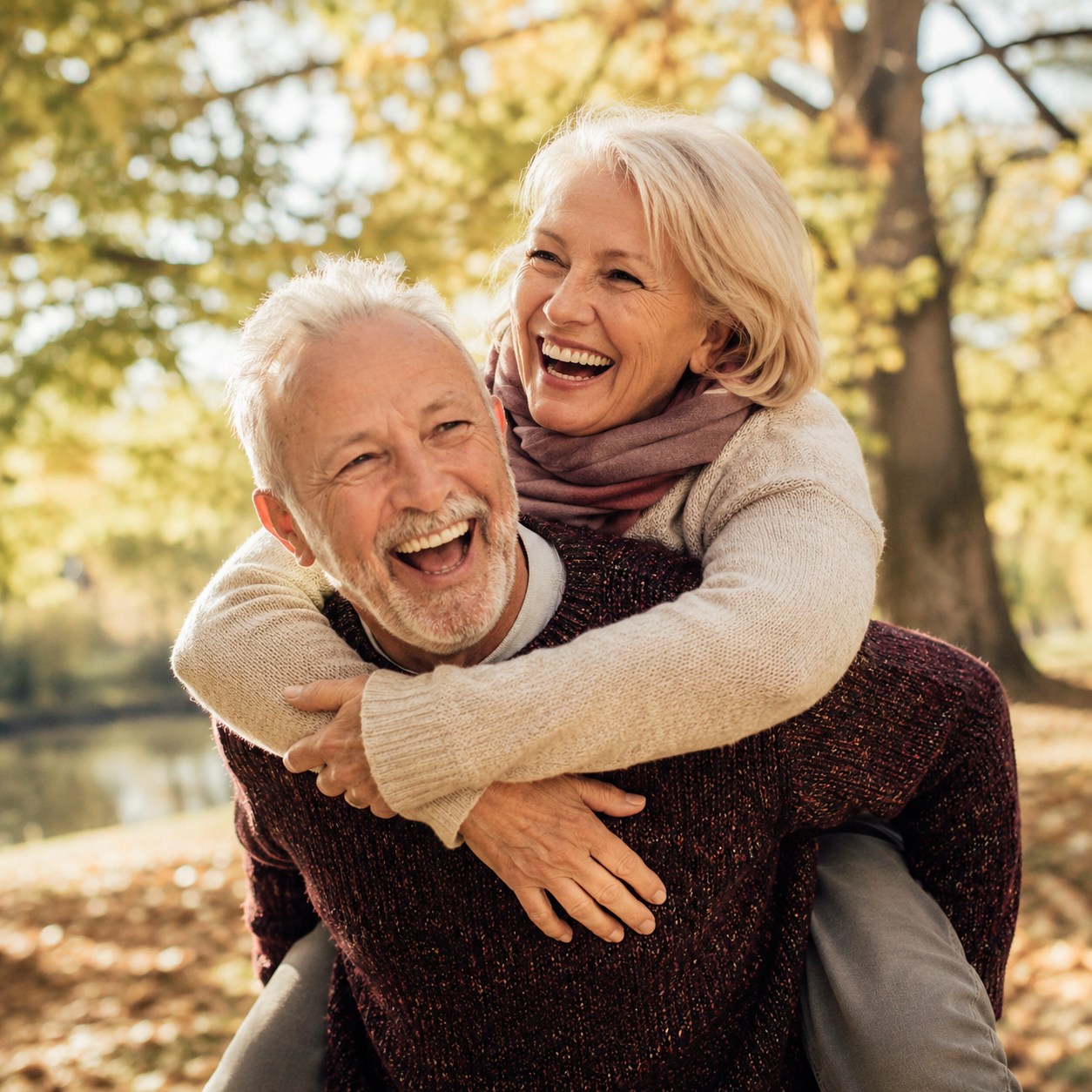 An older couple laughing together outdoors, enjoying life independently